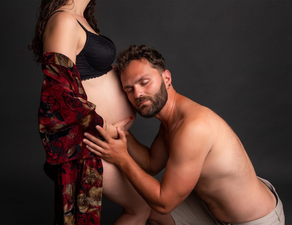 Fotografía de papá abrazando la barriguita de mami en el embarazo.