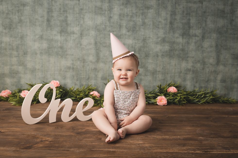 Primer plano de bebé con tarta en la cara durante sesión Smash Cake en estudio Kara & Melo