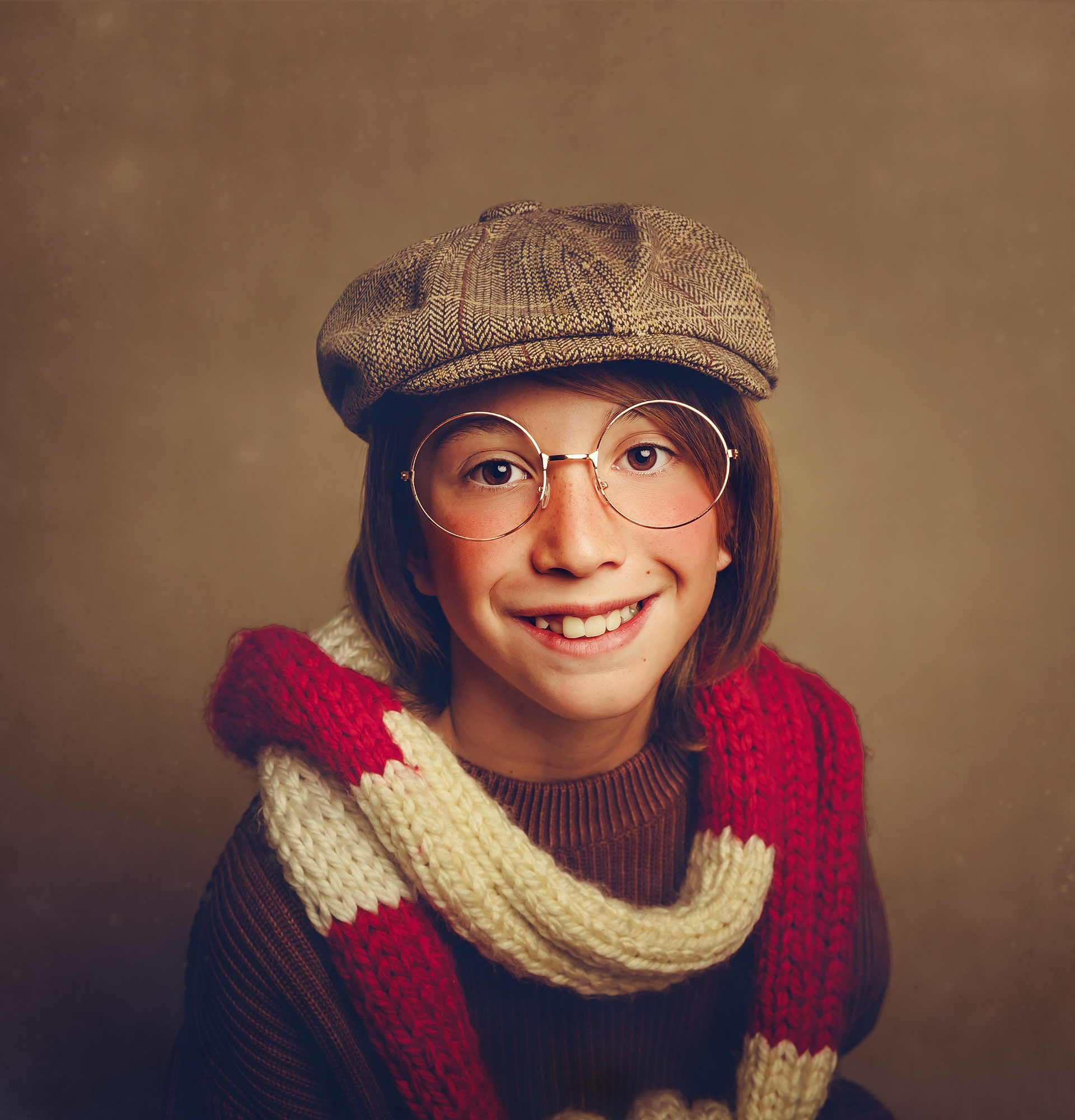 Niño con bufanda roja y gorra marrón en sesión de fotos de Navidad en estudio Kara & Melo Getafe