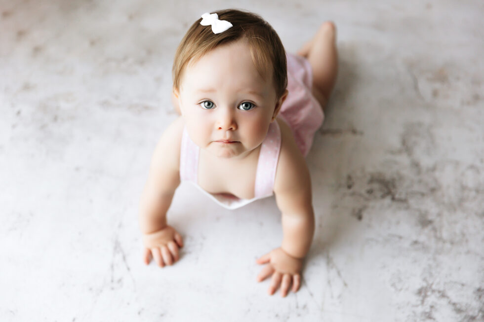Bebé en sesión fotográfica infantil sobre fondo blanco en estudio en Getafe Madrid, estilo natural y atemporal (Otra variante secundaria que también puedes usar en galería) Retrato de bebé en estudio con fondo claro y estética natural, fotografía infantil profesional en Madrid