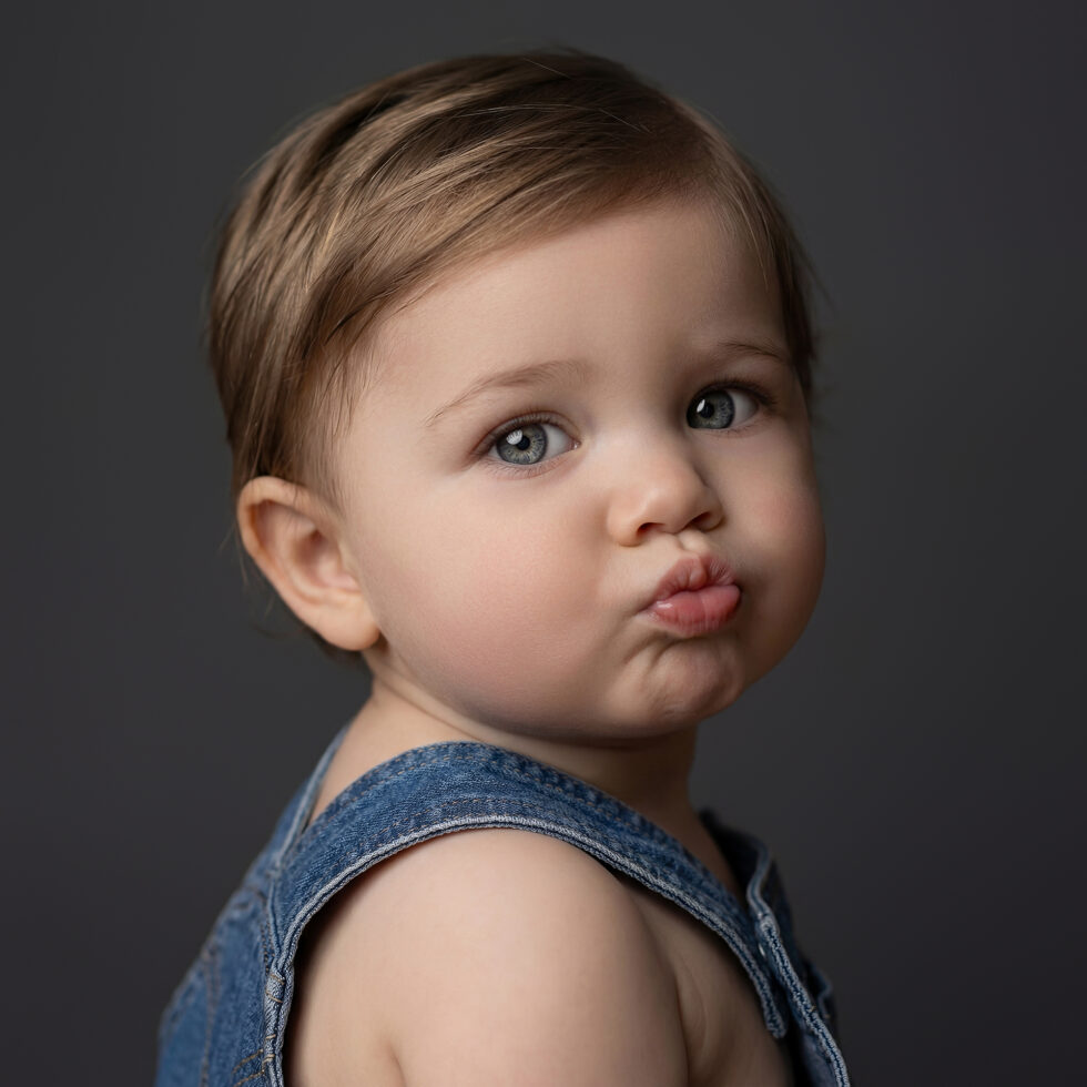 retrato artístico de bebé en estudio con fondo oscuro durante una sesión de fotografía infantil en Madrid