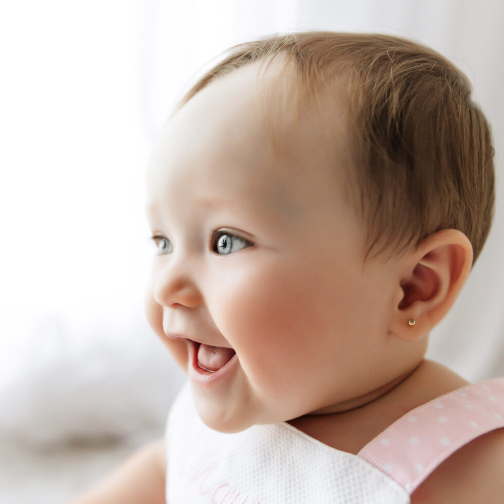 primer plano de bebé sonriendo durante una sesión de fotos infantil en estudio