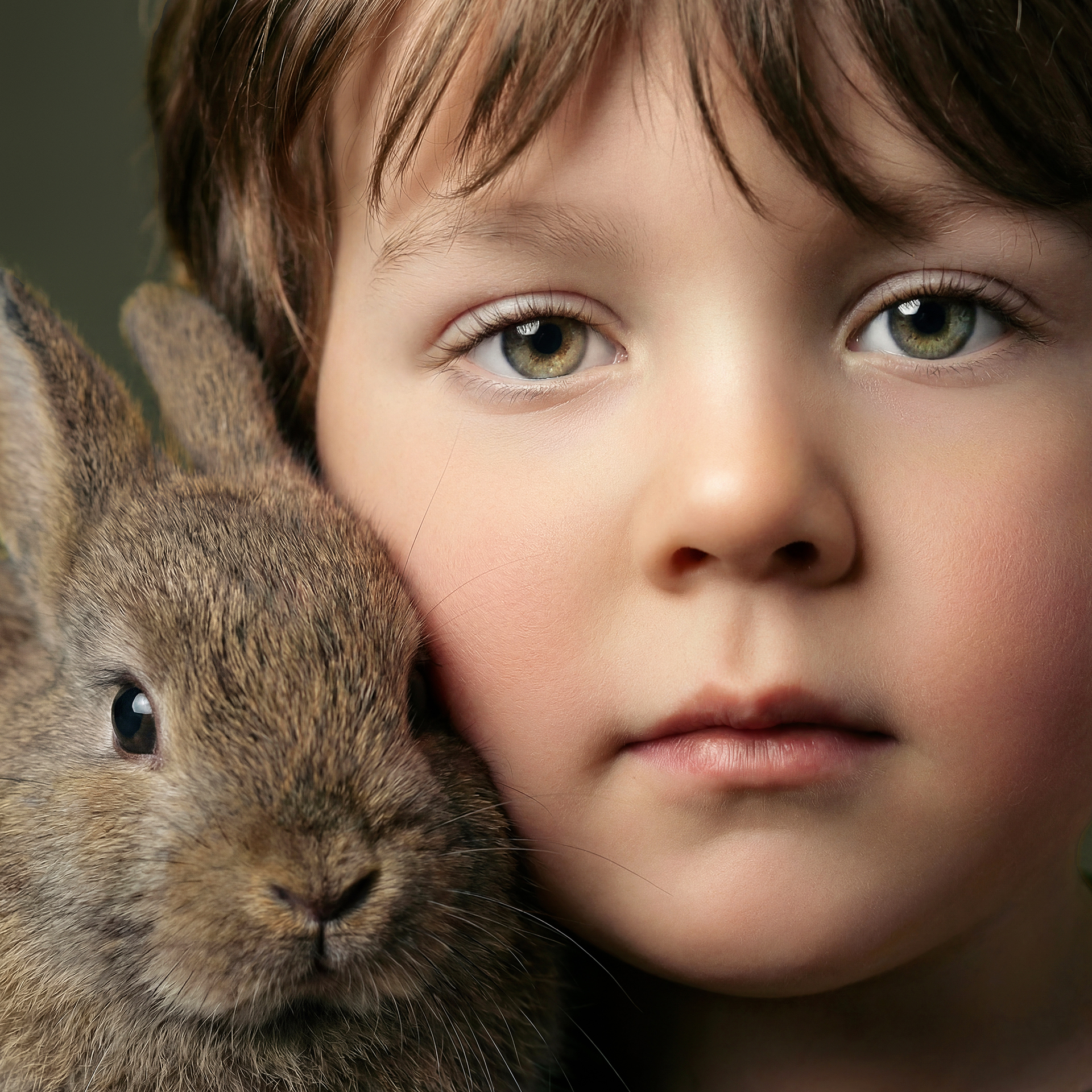 Retrato infantil artístico de niño con conejo en primer plano