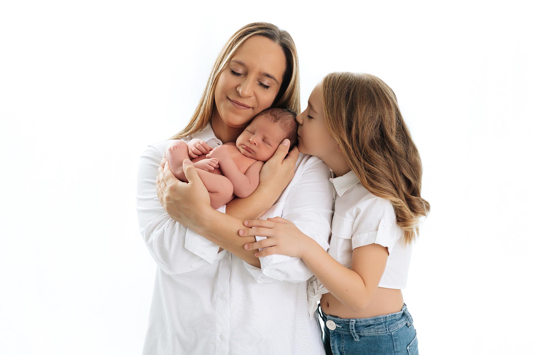 Hermano mayor con bebé recién nacido en sesión newborn en estudio